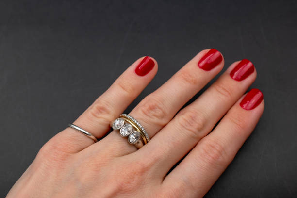 Gold wedding ring and diamond engagement ring stacked on finger